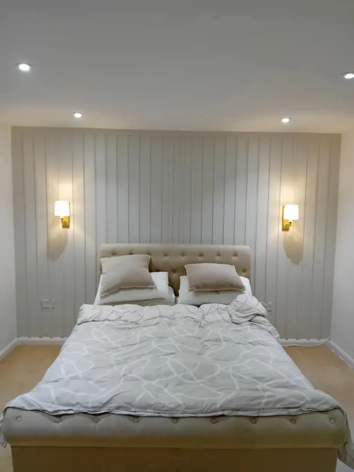 A large bed sitting in a bedroom next to two lamps.