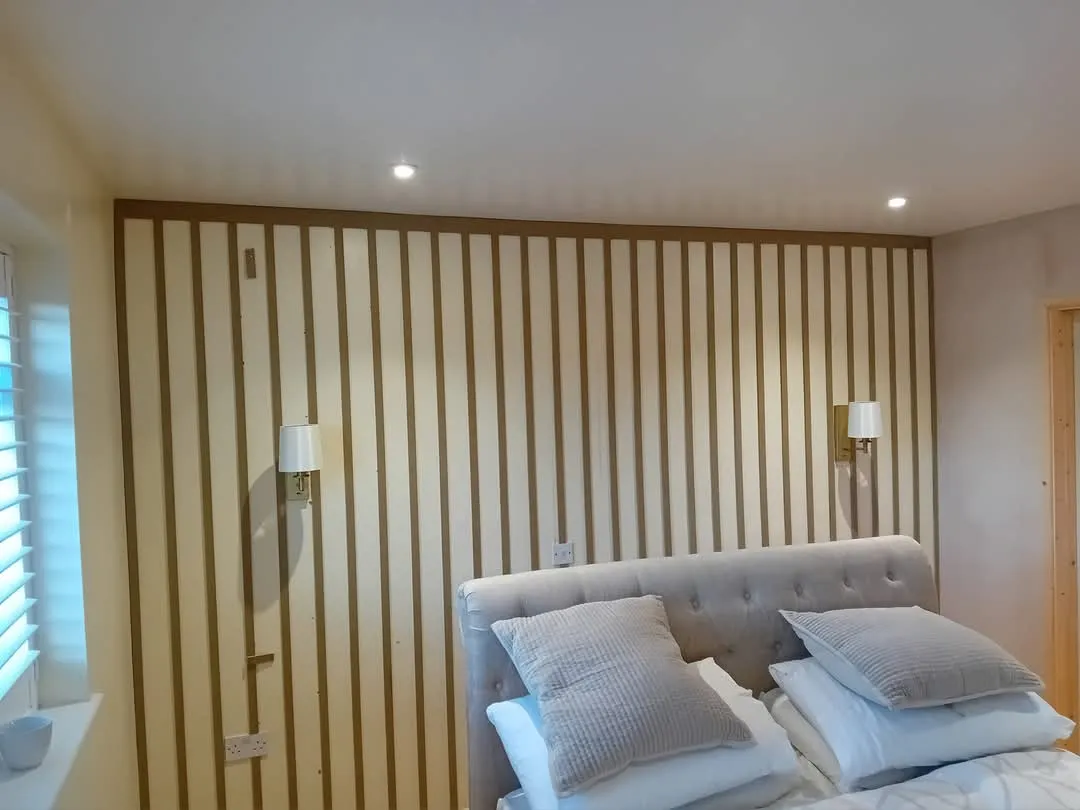 A bedroom with a bed and a wall with vertical blinds.