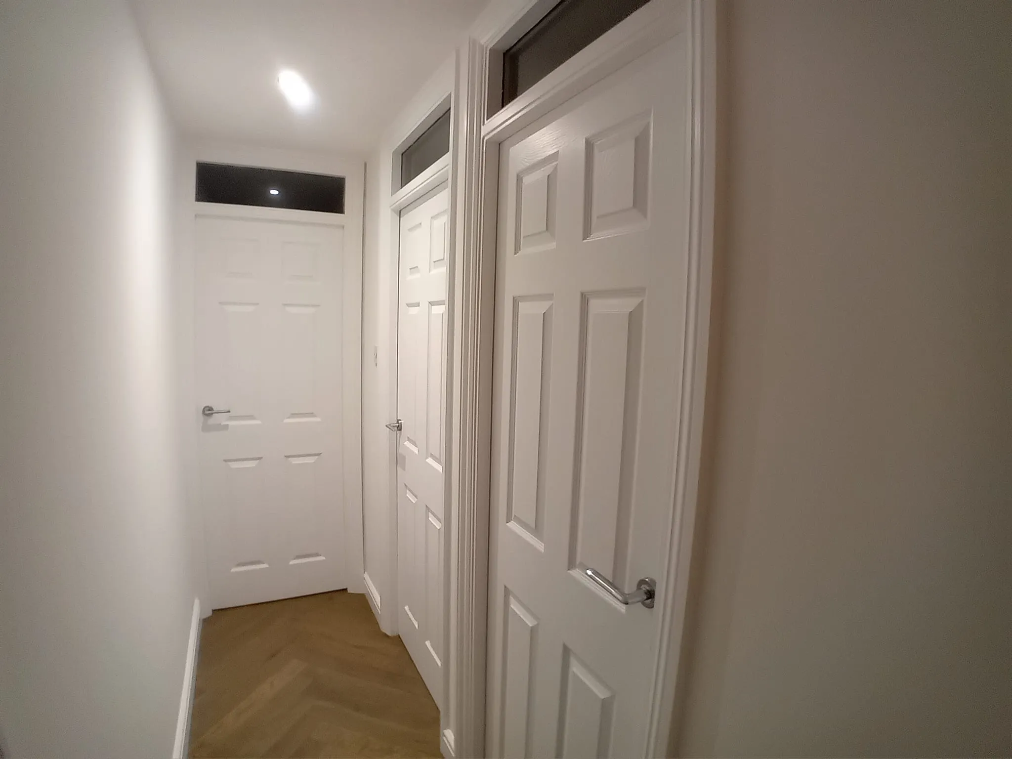 a hallway with two doors and a light