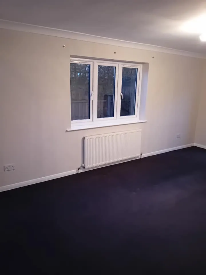 a room with a window and a black carpet