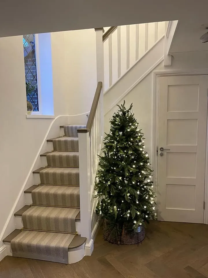 a christmas tree in a small room with stairs