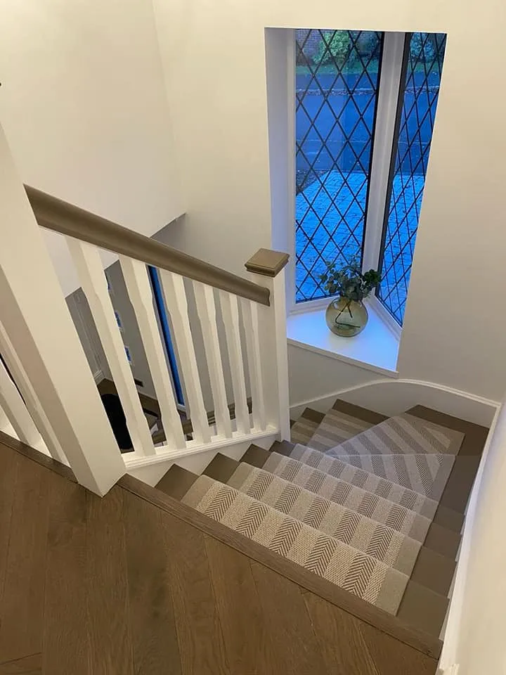 a staircase with a glass window and wooden floor
