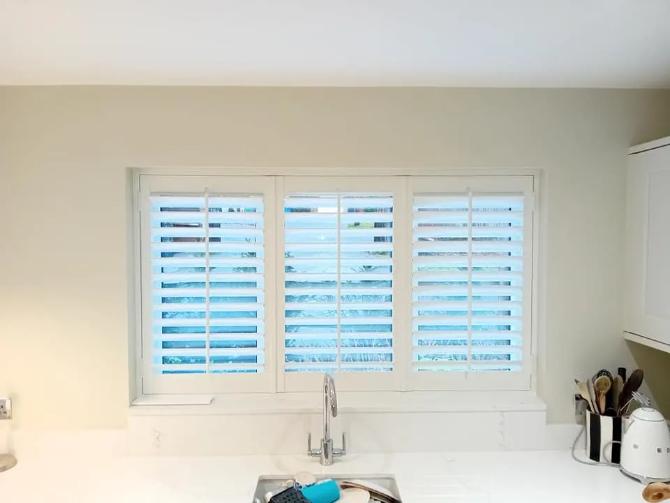 a kitchen with white cabinets and a window