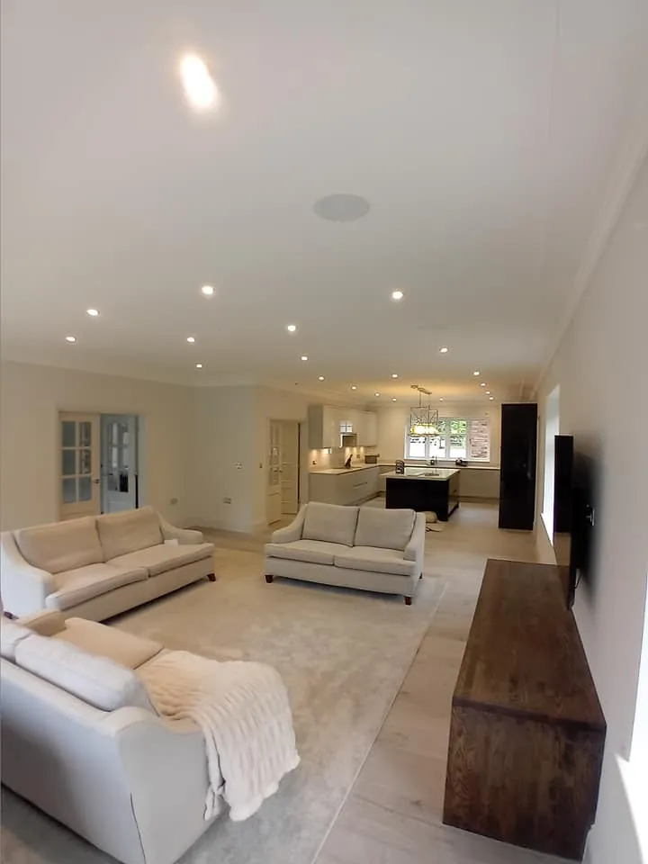 a living room with white furniture and a large window
