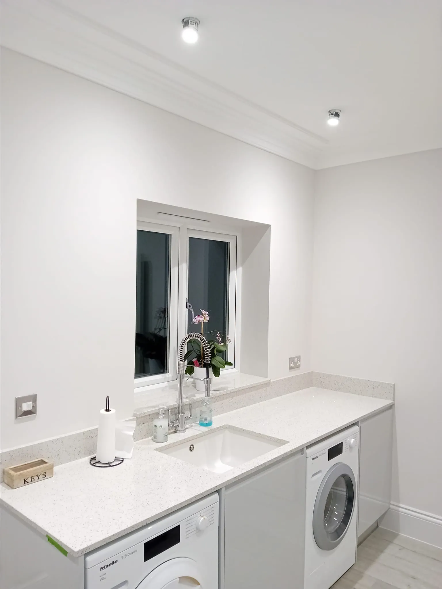a laundry room with a washer and a sink